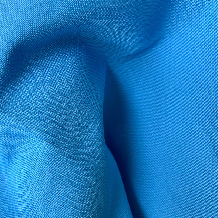 Close-up fabric swatch of Pacific Blue Outdoor Performance, a solid mid-blue indoor-outdoor performance weave